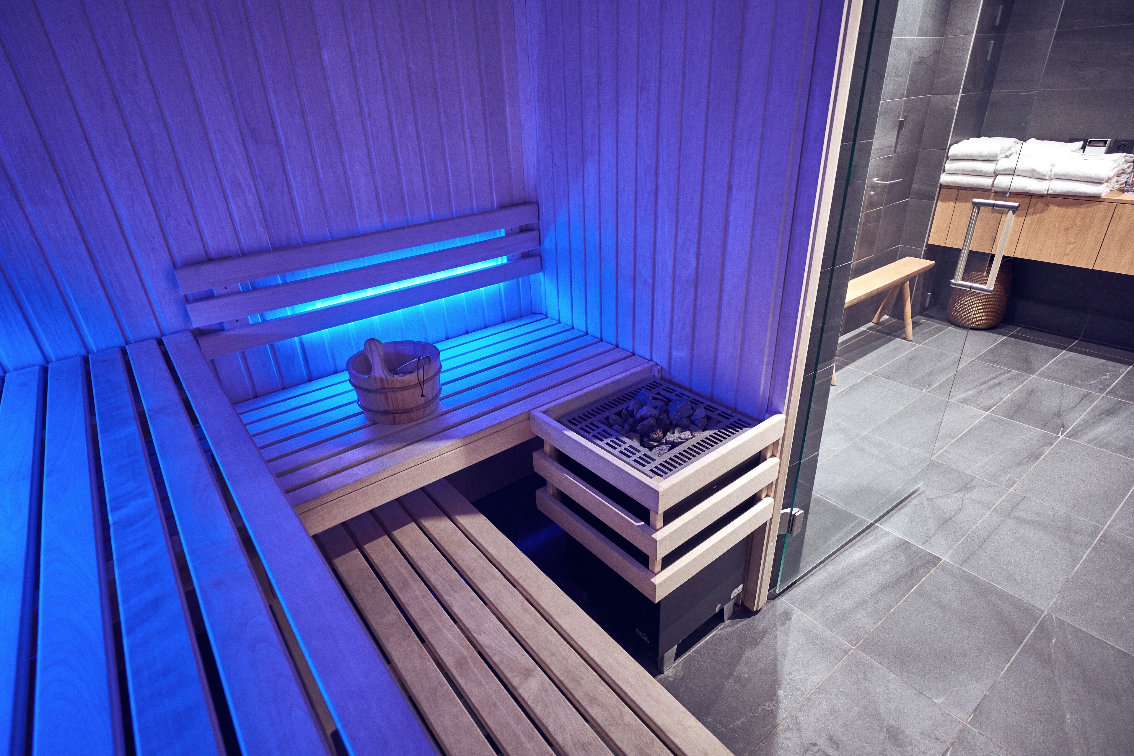 A sauna with wooden benches and a bench seat, a wooden bench, and a bench seat.