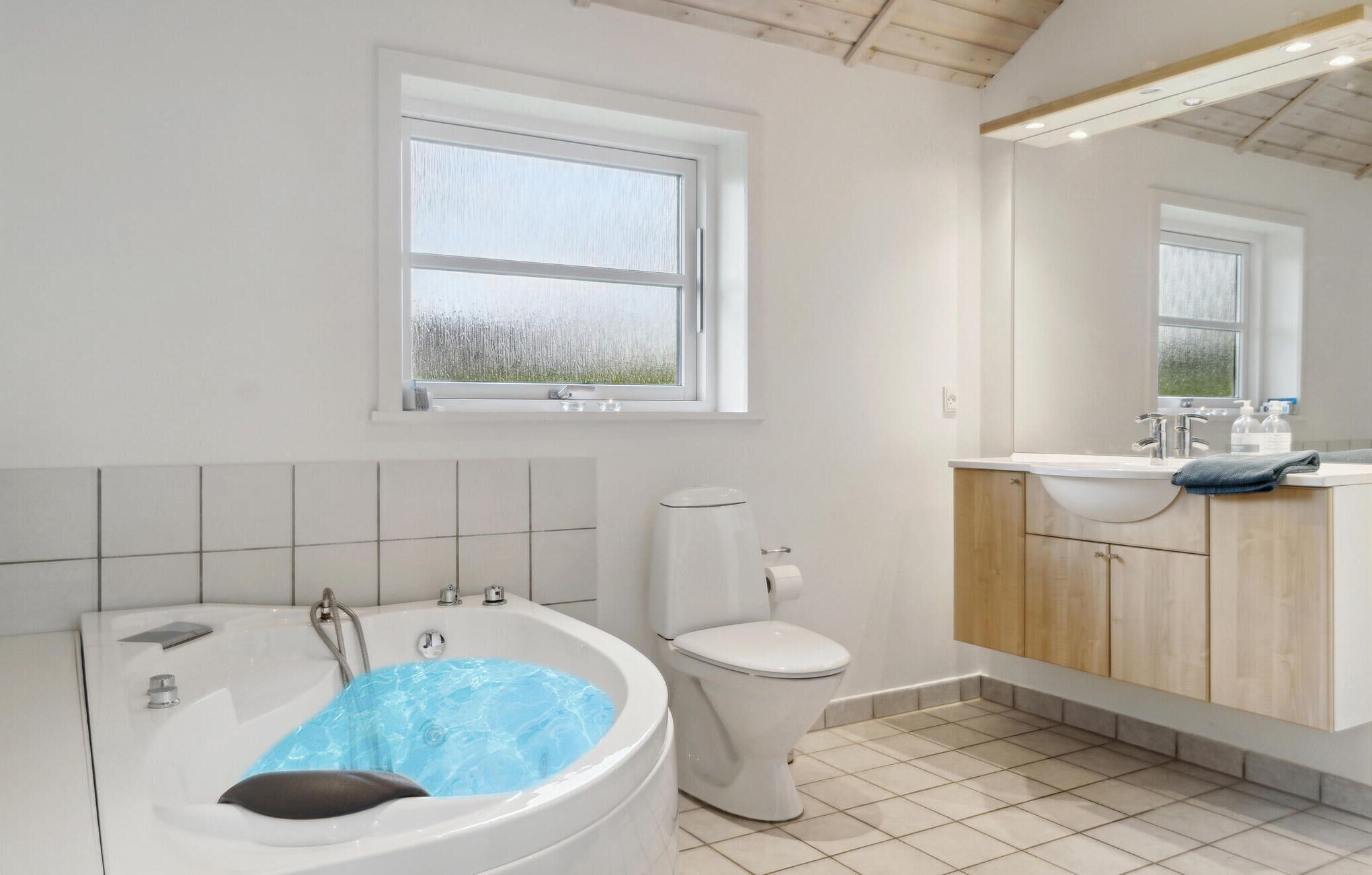 Un baño moderno con bañera, inodoro y tocador.