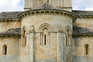 A historic stone building with a central tower, arched windows, and a tiled roof. - Finca Santa Eufemia (Olmos de Ojeda)