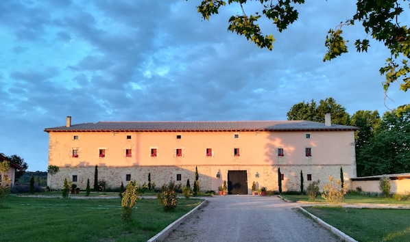 A large stone building with a tiled roof, multiple windows, and a central entrance. - Finca Santa Eufemia (Olmos de Ojeda)