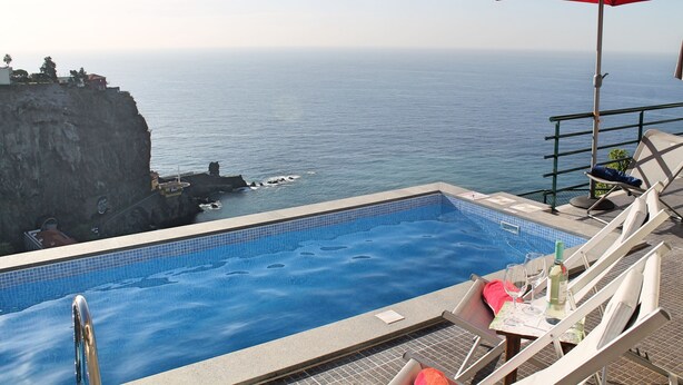 A pool with a view of the ocean and a cliff. - Casa Jardim Mar by Our Madeira (Calheta)