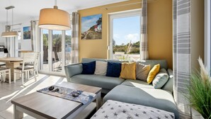 A modern living room with a sofa, coffee table, and dining area. - Nice home in Glowe with WiFi (Glowe)
