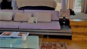 Ein Schlafzimmer mit Bett, Sofa, Nachttisch und Beistelltisch.