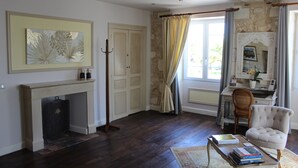 Une pièce avec une cheminée, un bureau, une chaise et une bibliothèque.