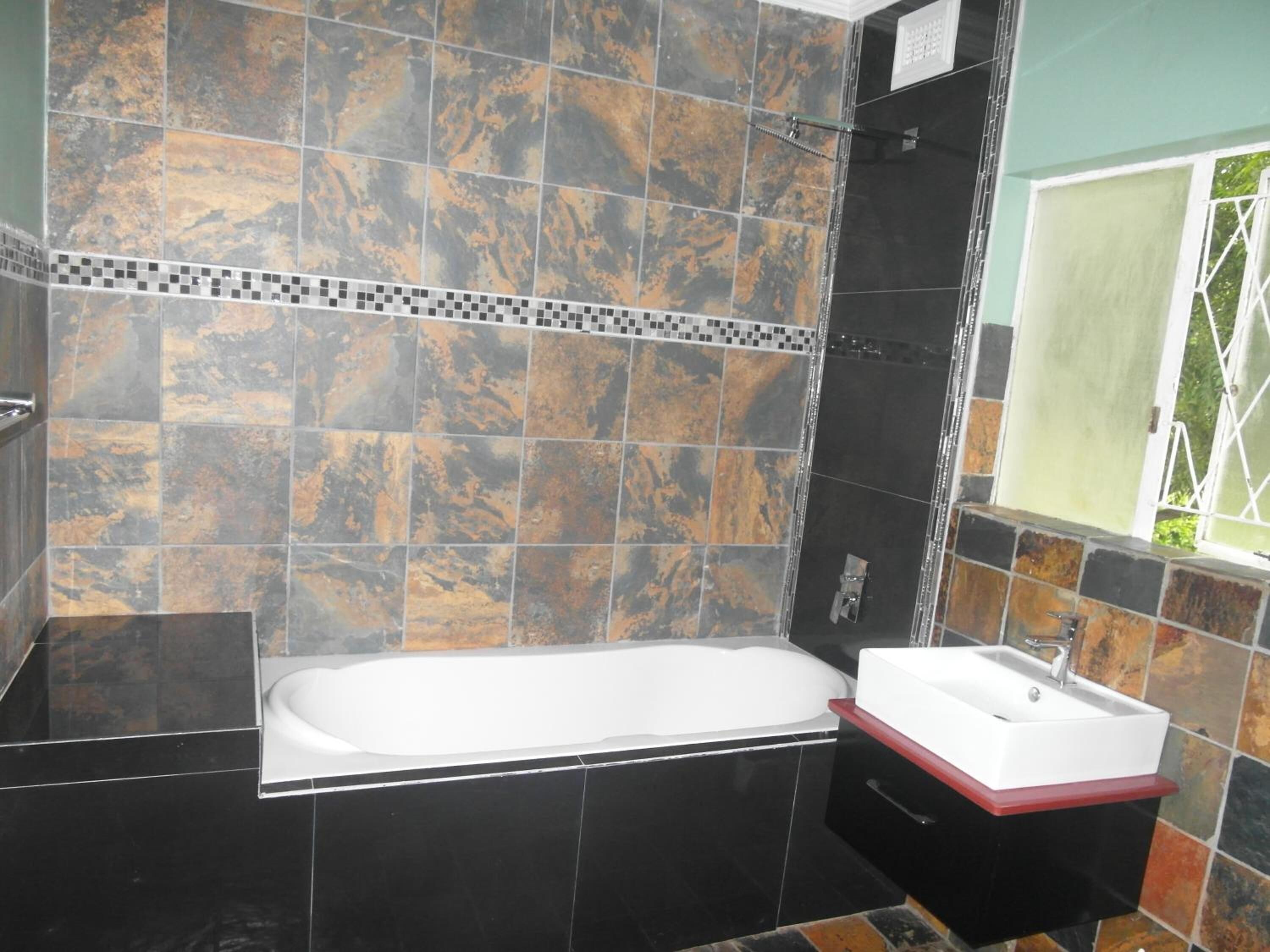 A bathroom with a bathtub, a sink, and a window.