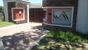 Una entrada protegida con fachada de piedra y un cartel que indica Lake Sands Manor.
