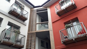 A multi-story building with balconies, some with plants. - B&B Corte Rossa (Tirano)