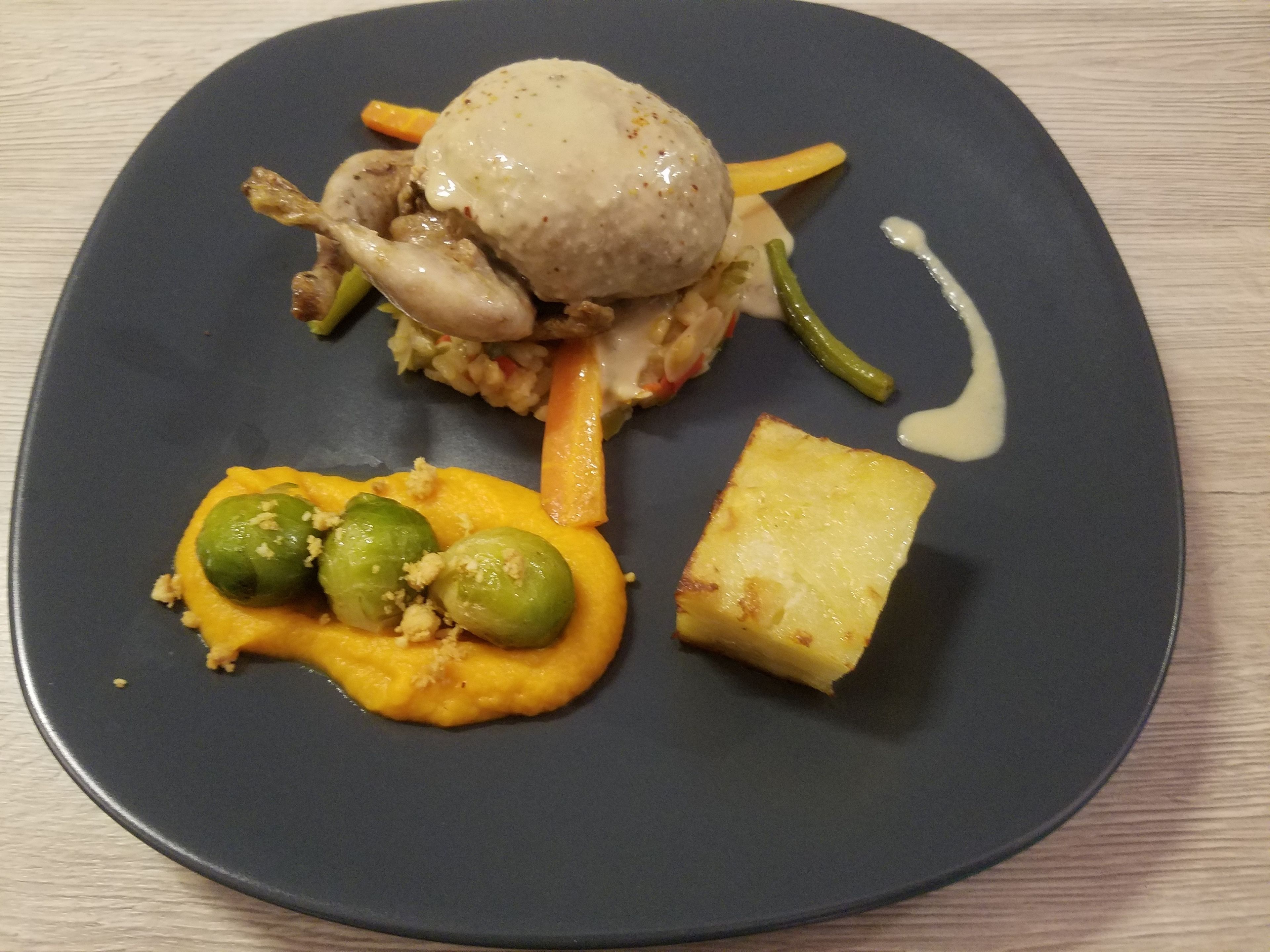 A plate with a variety of food items including a piece of chicken, a scoop of mashed potatoes, a slice of pineapple, and a side of green vegetables.
