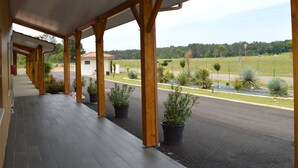 A covered outdoor area with wooden beams and potted plants. - L'Hôtel du Lac (Casteljaloux)