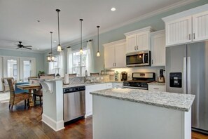 Enjoy cooking in this well-equipped kitchen with a central island, stainless steel appliances, and ample cabinetry.