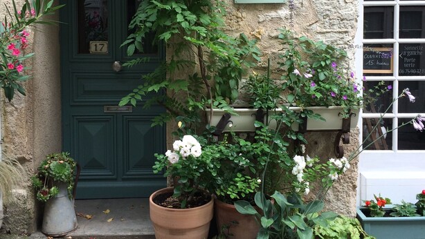 Un edificio rústico con una puerta verde, un cartel que dice 