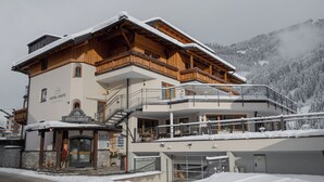 Un hotel con fachada de madera, balcones y un cartel que dice 'HOTEL GRATZ'.