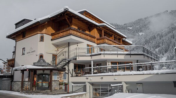 Un hotel con fachada de madera, balcones y un cartel que dice 'HOTEL GRATZ'.
