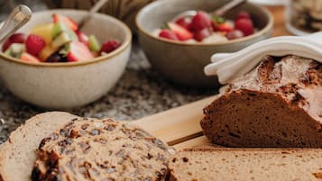 A wooden cutting board with sliced bread and a loaf of bread.