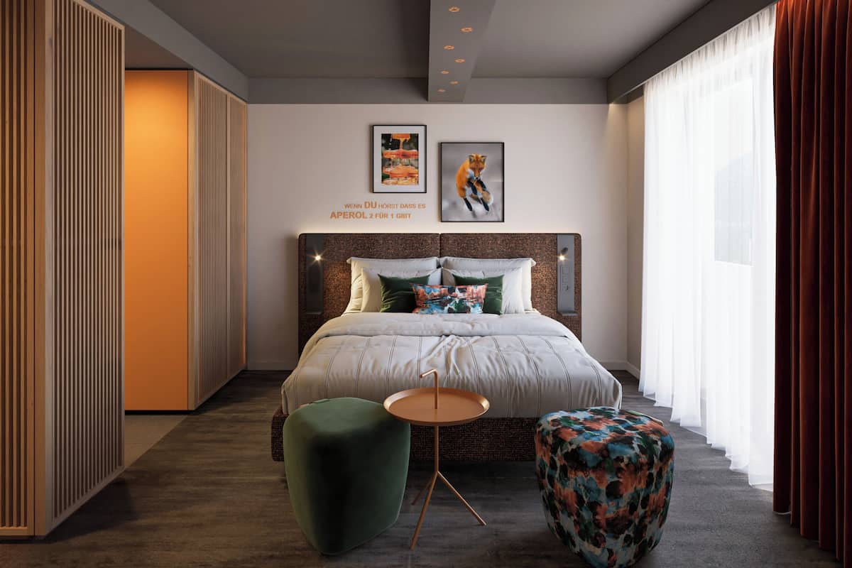 Un dormitorio moderno con una cama grande, una mesita redonda pequeña y un taburete verde.