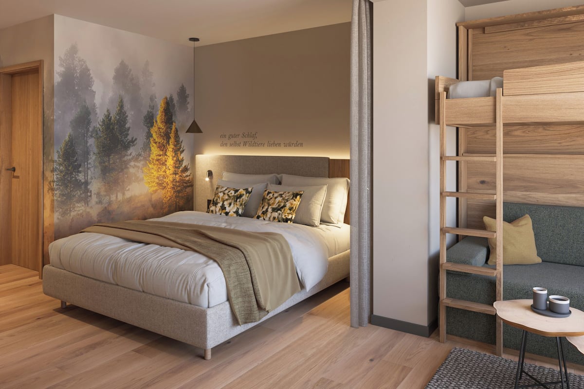 Un dormitorio con cama, un mural en la pared, una escalera de madera y una mesita con velas.