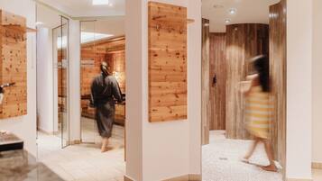 Un pasillo de hotel con paneles de madera, una puerta de cristal y piso de baldosas.