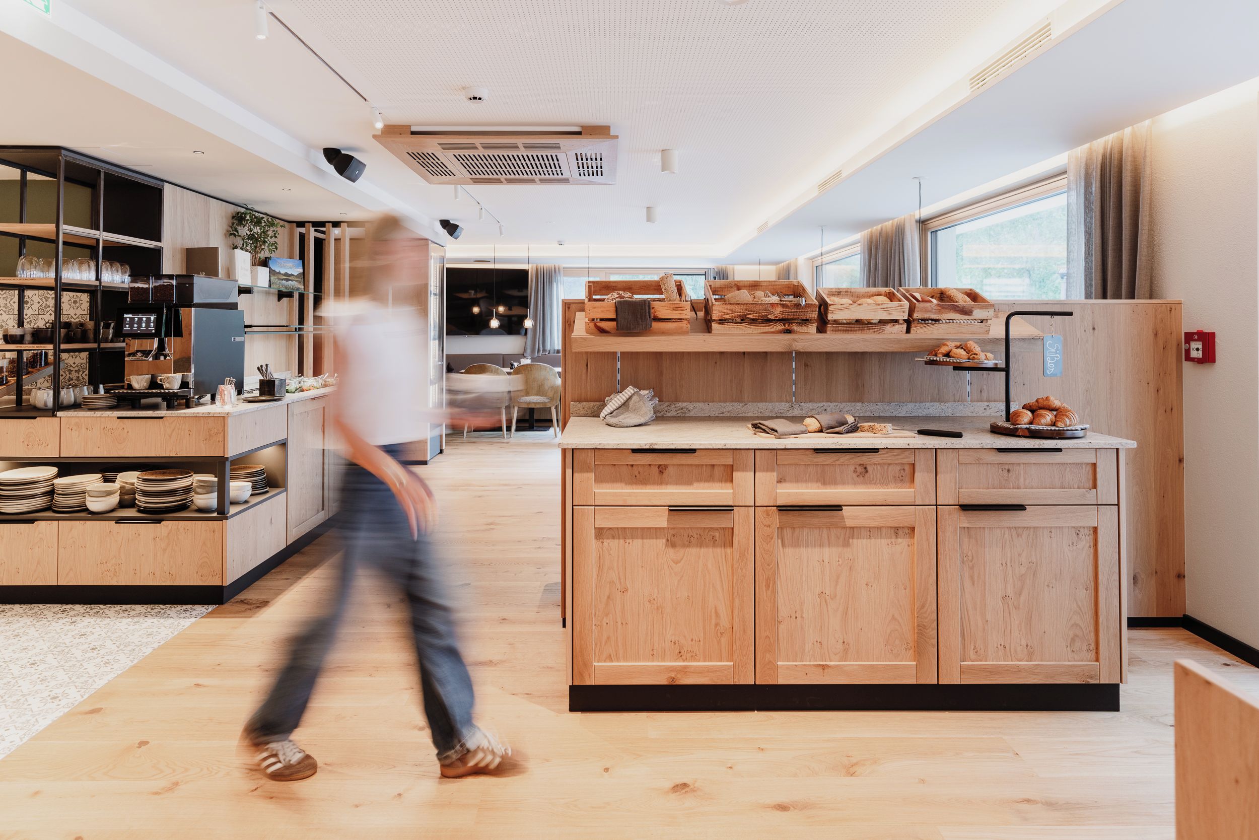 Una cocina moderna con armarios de madera, una isla central y un comedor con vistas.