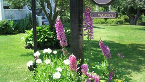 A garden with various flowers and a 'VACANCY' sign. - Bittersweet Bed and Breakfast (York Beach)