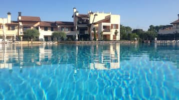 Una piscina al aire libre de temporada, sillones reclinables de piscina