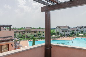 Blick auf einen Poolbereich mit mehreren Gebäuden im Hintergrund.