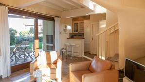 A spacious living area with a sofa, a dining table, and a kitchen in the background. - Lugana Village Resort & Sporting Club (Peschiera del Garda)