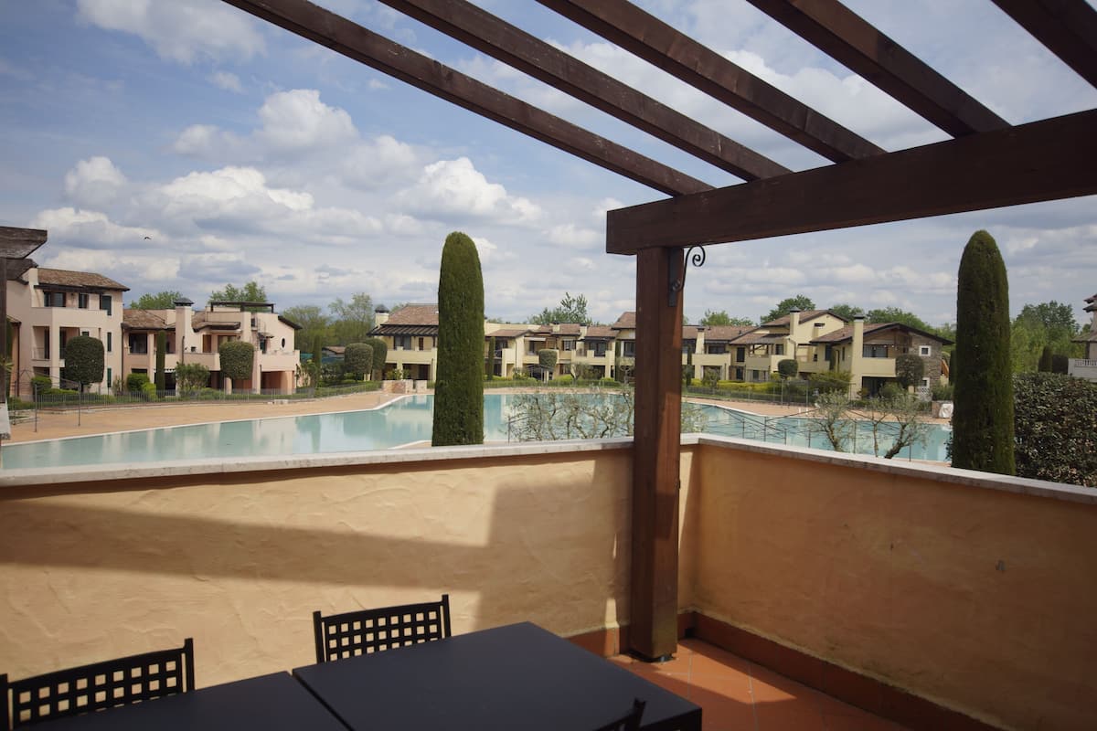 Un balcon donnant sur une piscine et des immeubles d’habitation.