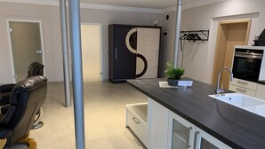 A modern kitchen with a dark countertop, white cabinets, and a stainless steel sink. - Apartment Ahsbahs Suite near Airport (Elskop)