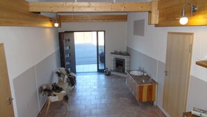 A bathroom with a wooden ceiling, a fireplace, a sink, and a door leading to a balcony.