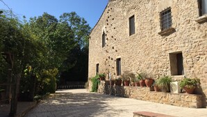 Un edificio de piedra con varias ventanas y plantas en macetas.