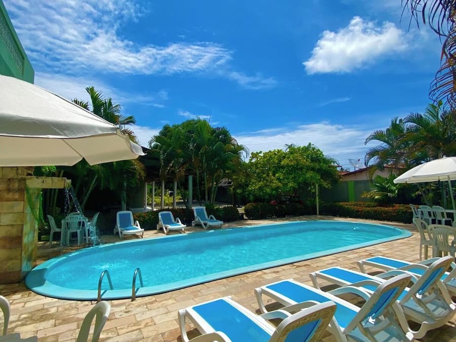 Una piscina al aire libre, sillones reclinables de piscina