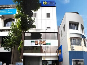 A hotel named 'Pranava Deluxe' with a modern facade, a visible entrance, and signage for 'fabHOTELS' above.