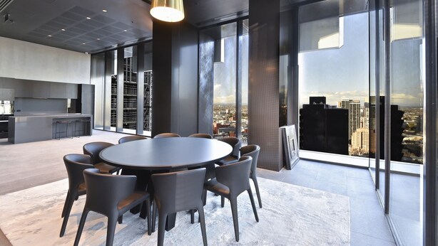 Una sala de reuniones moderna con una mesa redonda, sillas y vistas a la ciudad a través de amplios ventanales.
