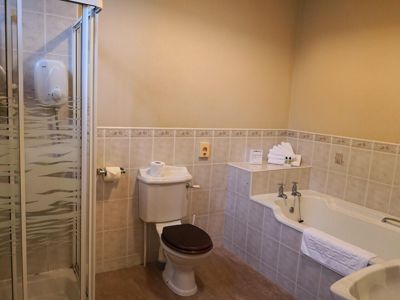 A bathroom with a toilet, shower, and bathtub.