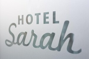 Un letrero de hotel con el nombre 'HOTEL Sarah' en una tipografía estilizada.