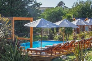 Een binnenzwembad, 2 buitenzwembaden en parasols bij het zwembad