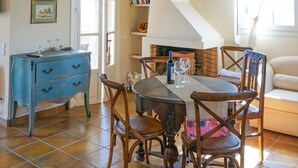 A dining area with wooden chairs, a table, and a chandelier. - Alekos Beach Houses - Natura Gialla (Kefalonia)