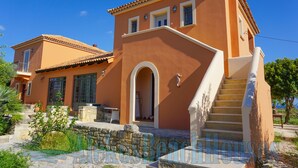 A two-story house with a stone staircase and a small balcony. - Alekos Beach Houses - Natura Gialla (Kefalonia)