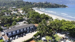 A beachfront hotel with a pool, palm trees, and ocean views. - PRIS Hotel (São Sebastião)
