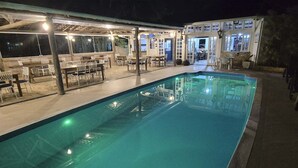 A swimming pool with adjacent outdoor seating and a covered area, likely for dining or relaxation. - PRIS Hotel (São Sebastião)