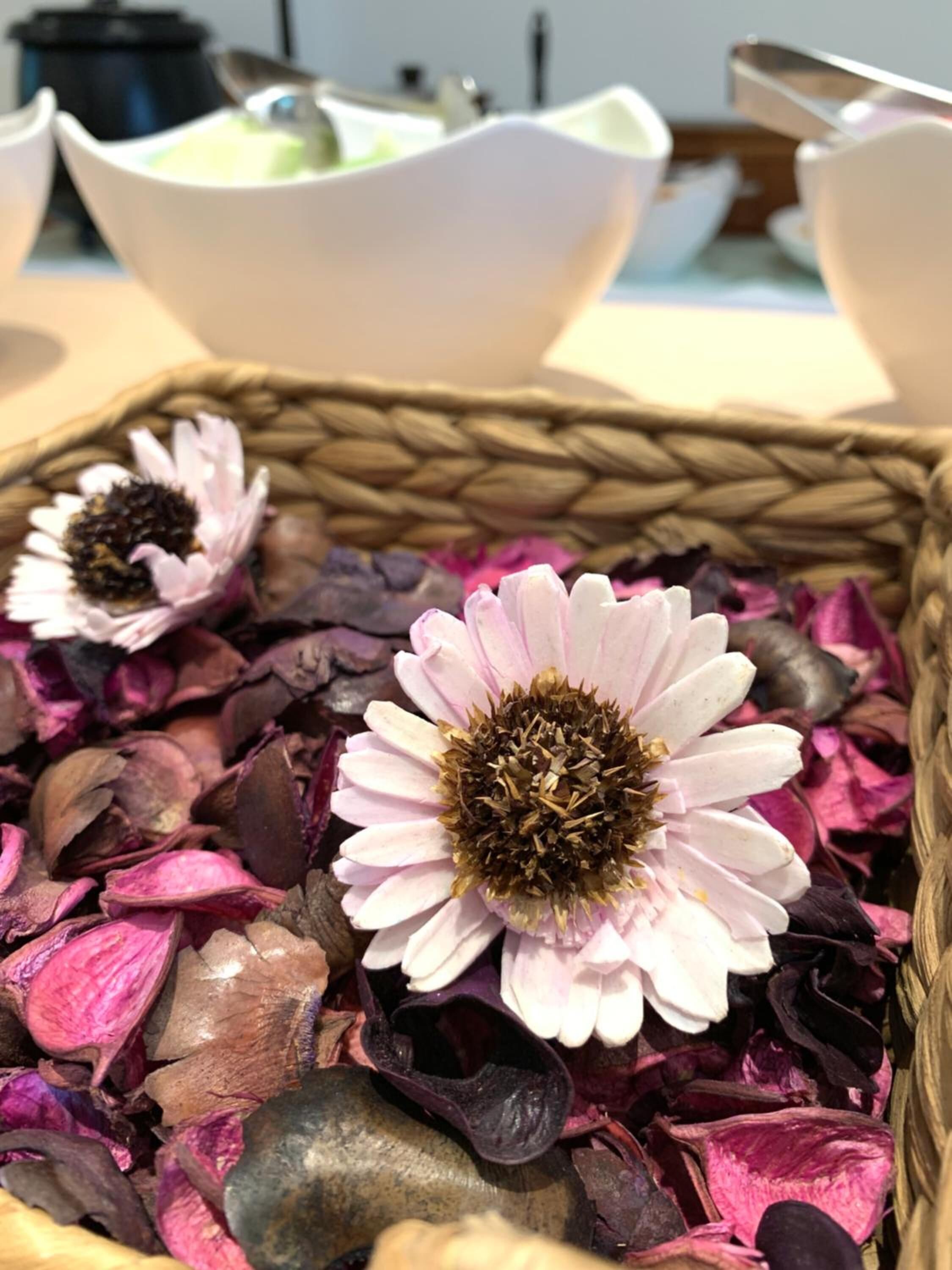A woven basket filled with dried flowers and petals.