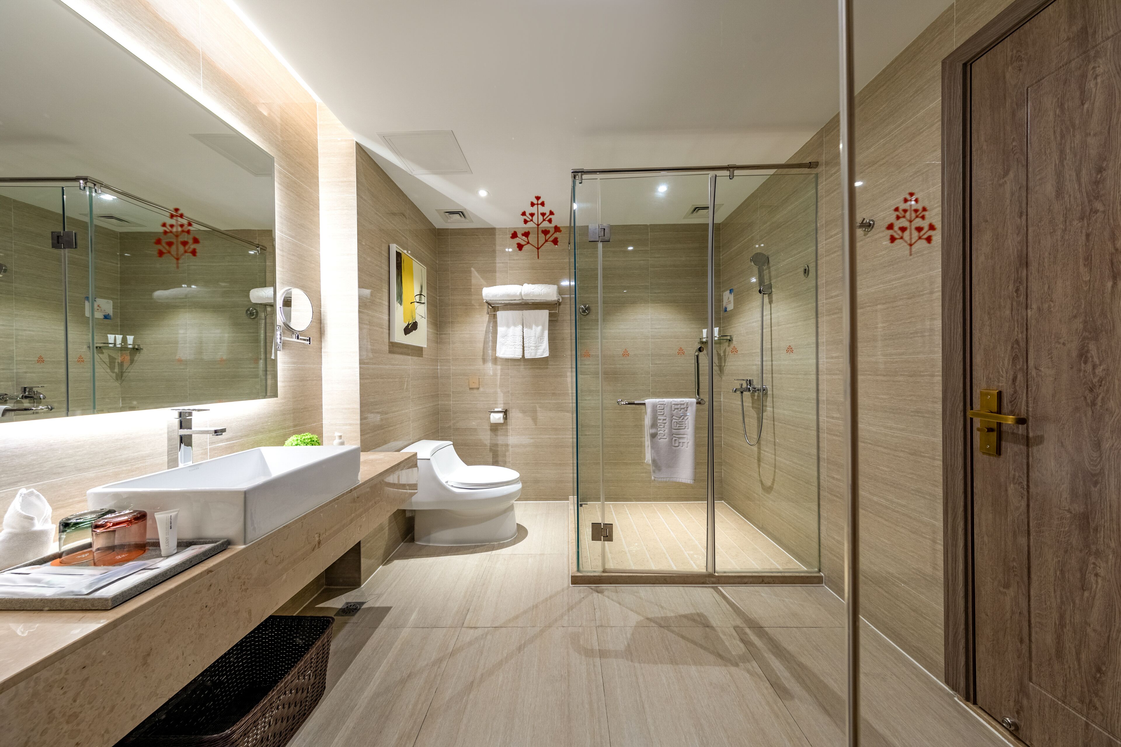 A modern bathroom with a glass-enclosed shower, a large mirror, and a vanity with a sink and toilet.