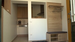 Una cocina compacta equipada con lavavajillas, cafetera y un armario de madera.