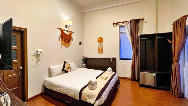 A hotel room with a bed, a TV, a desk, and a minibar. - HANZ Thien Nien Ky Hotel Da Lat (Cam Ly - Da Lat)