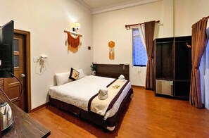 Une chambre d’hôtel équipée d’un lit, d’une télévision, d’un bureau et d’un mini-bar.
