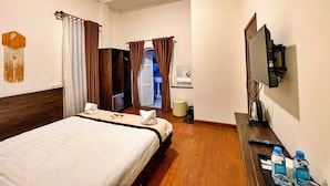A hotel room with a bed, a TV, a desk with a remote, and a bathroom visible through an open door. - HANZ Thien Nien Ky Hotel Da Lat (Cam Ly - Da Lat)