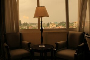 Une pièce comprenant deux fauteuils en cuir, une petite table ronde et un lampadaire.