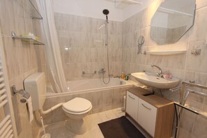 A modern bathroom with a bathtub, toilet, sink, and shower. - Ferienwohnung Riefenbach (Bad Harzburg)