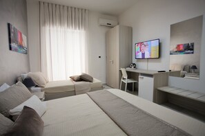 A modern hotel room with a bed, a desk, and a TV. - Central Apartments (Crotone)