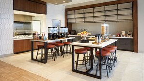 A modern kitchen with a central island, bar stools, and a coffee machine. - Hilton Garden Inn Elizabethtown, KY (Elizabethtown)